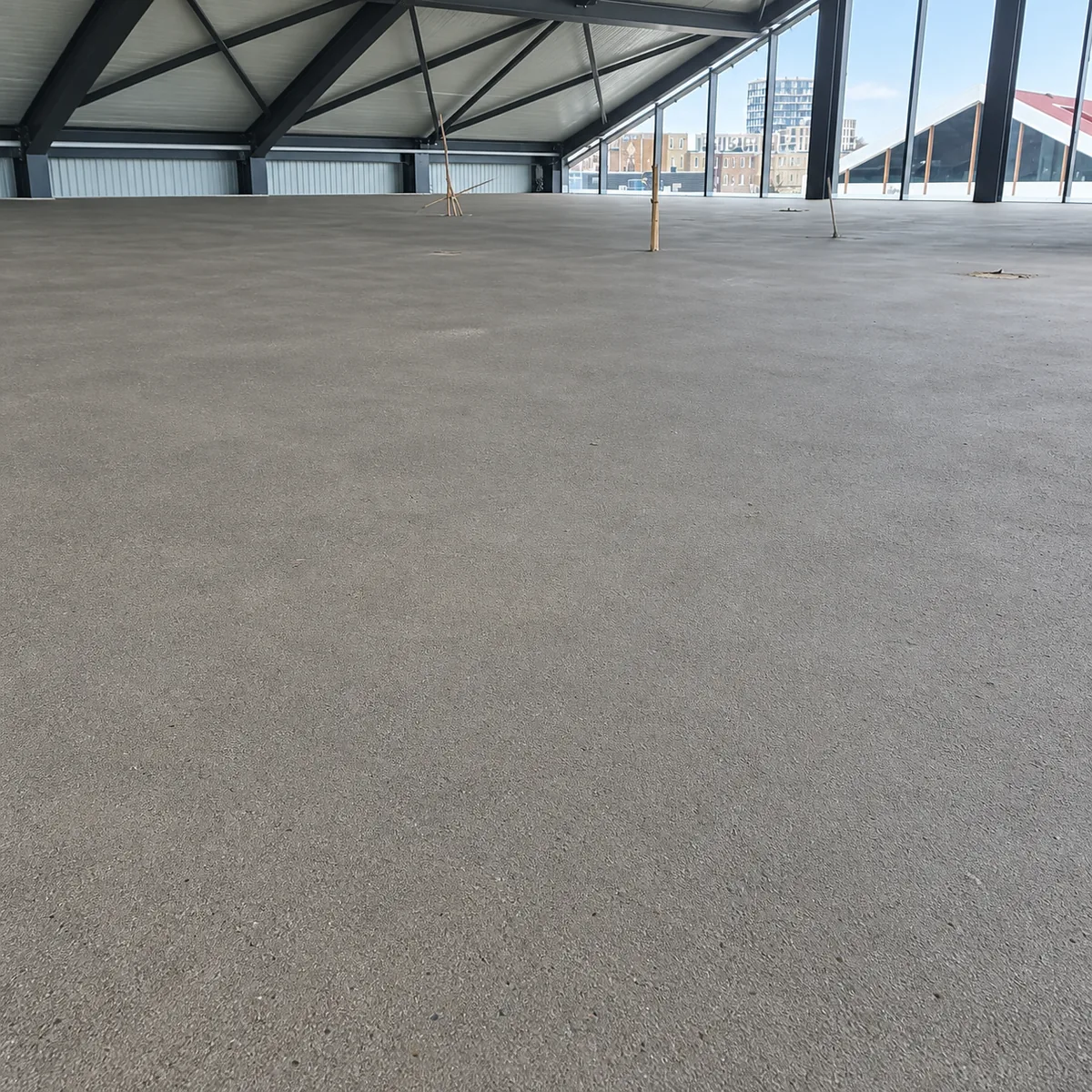 Vlak afgewerkte zandcementvloer in een groot bedrijfspand